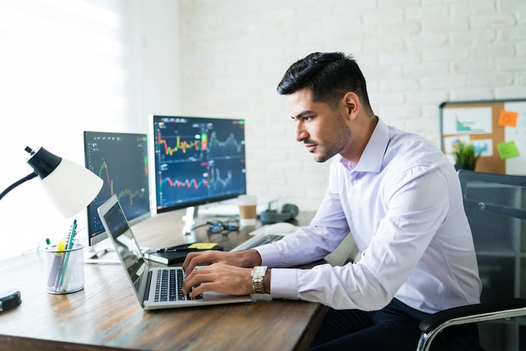 handsome-latin-freelance-broker-trading-through-laptop-desk-while-working-from-home_662251-702